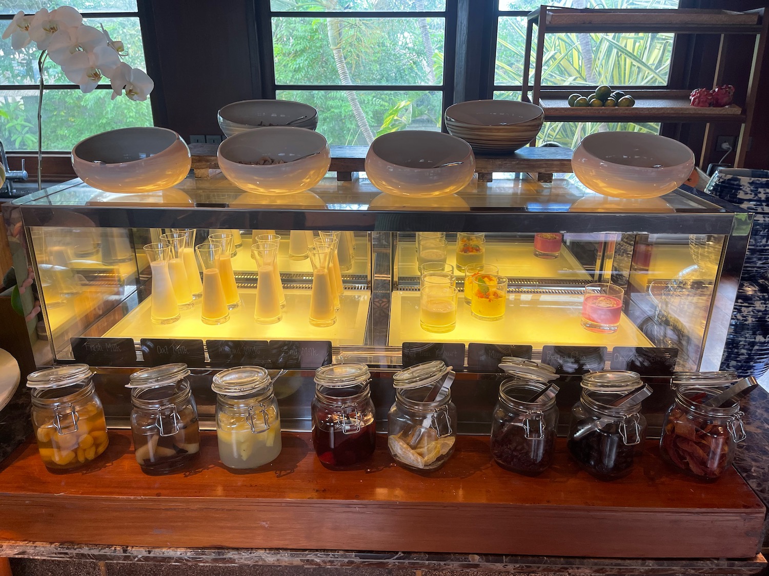 a glass display case with bowls and jars of jam