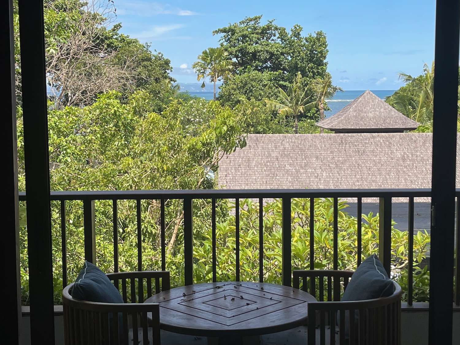 a balcony with a table and chairs and trees