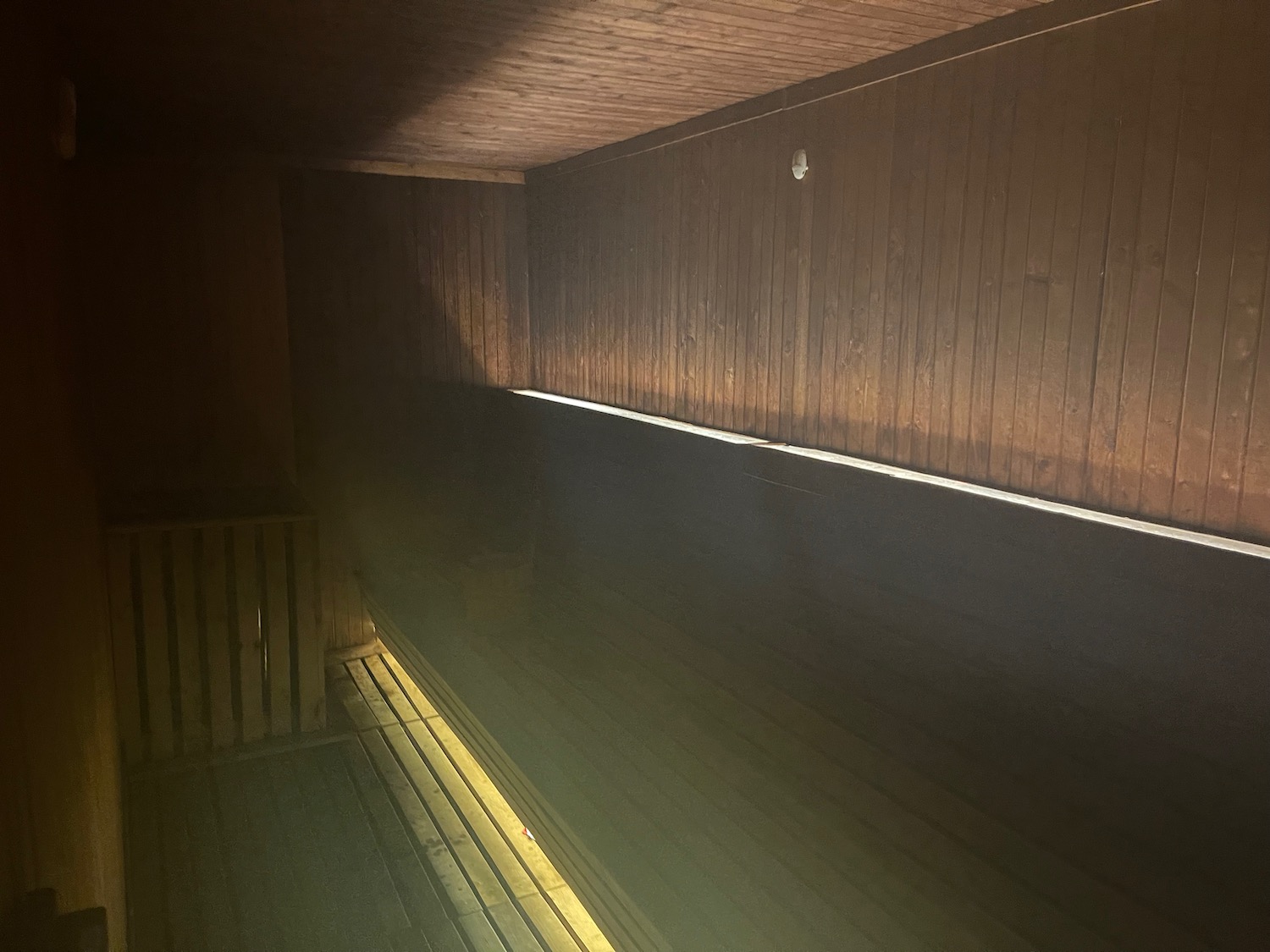 a wooden room with a light shining on the walls