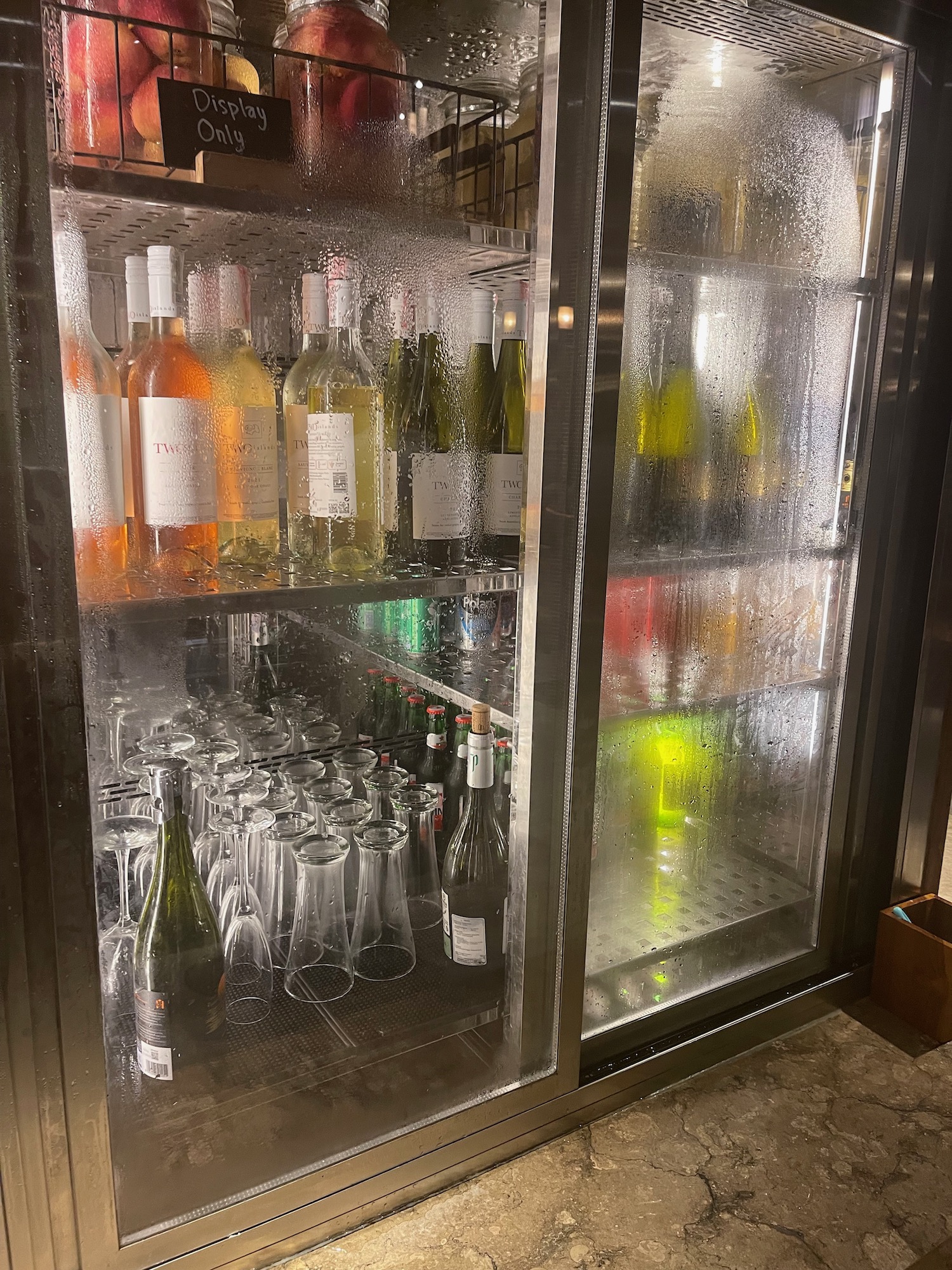 a refrigerator with bottles and glasses