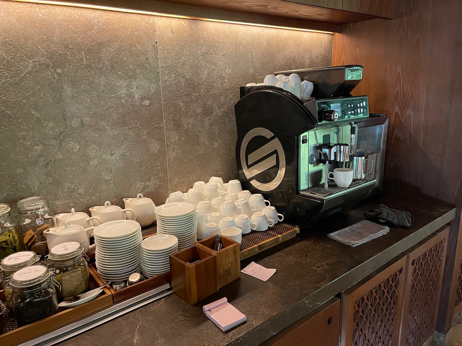 a coffee machine with white cups and plates on a counter
