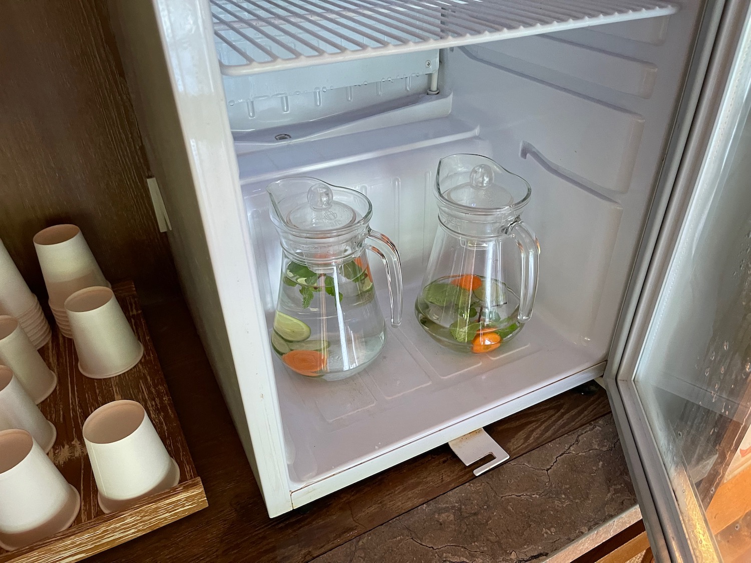 two glass jugs with water inside of a refrigerator