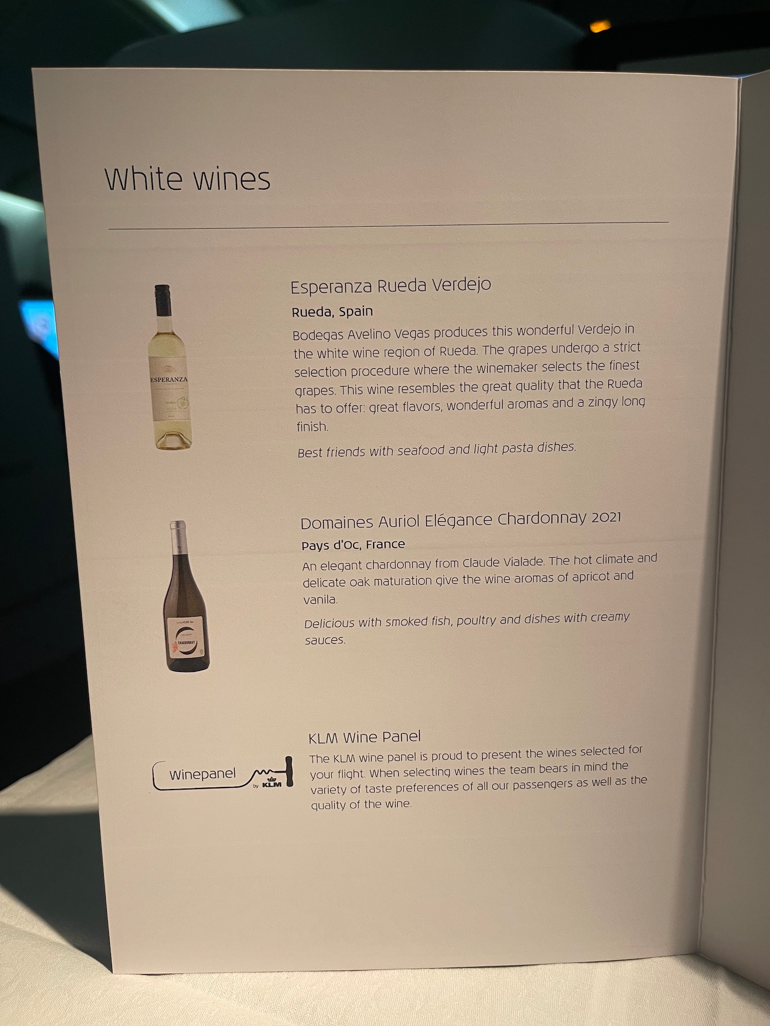 a white sign with text and pictures of wine bottles