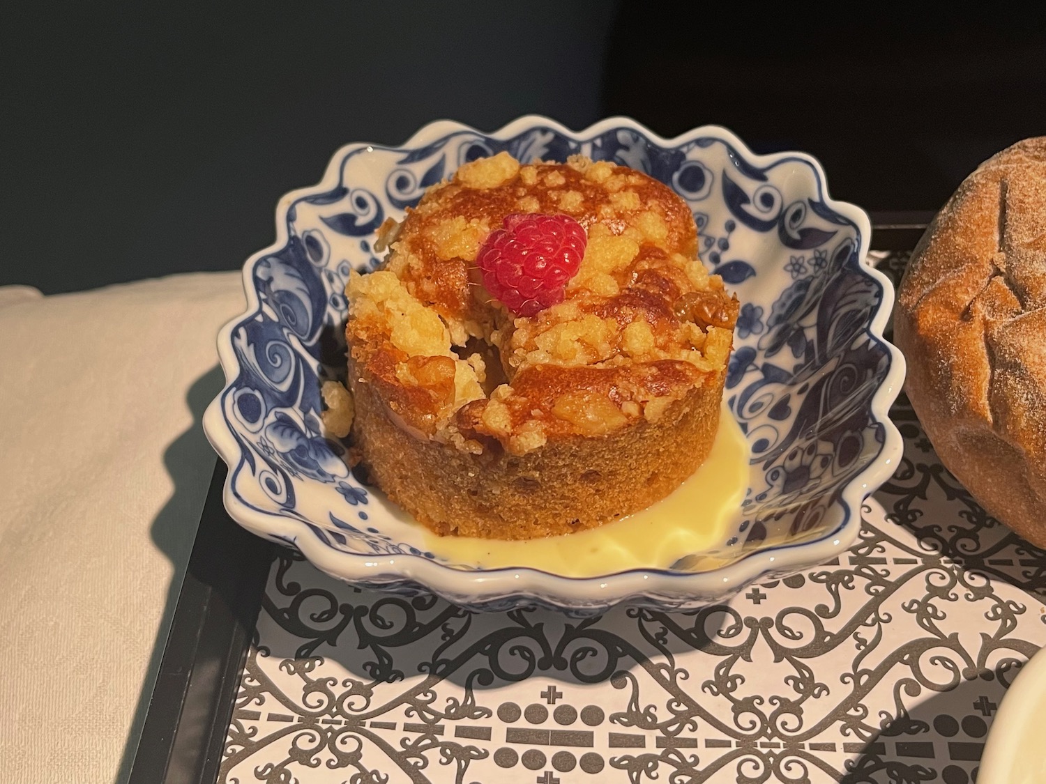 a blue and white bowl with a small round pastry on it