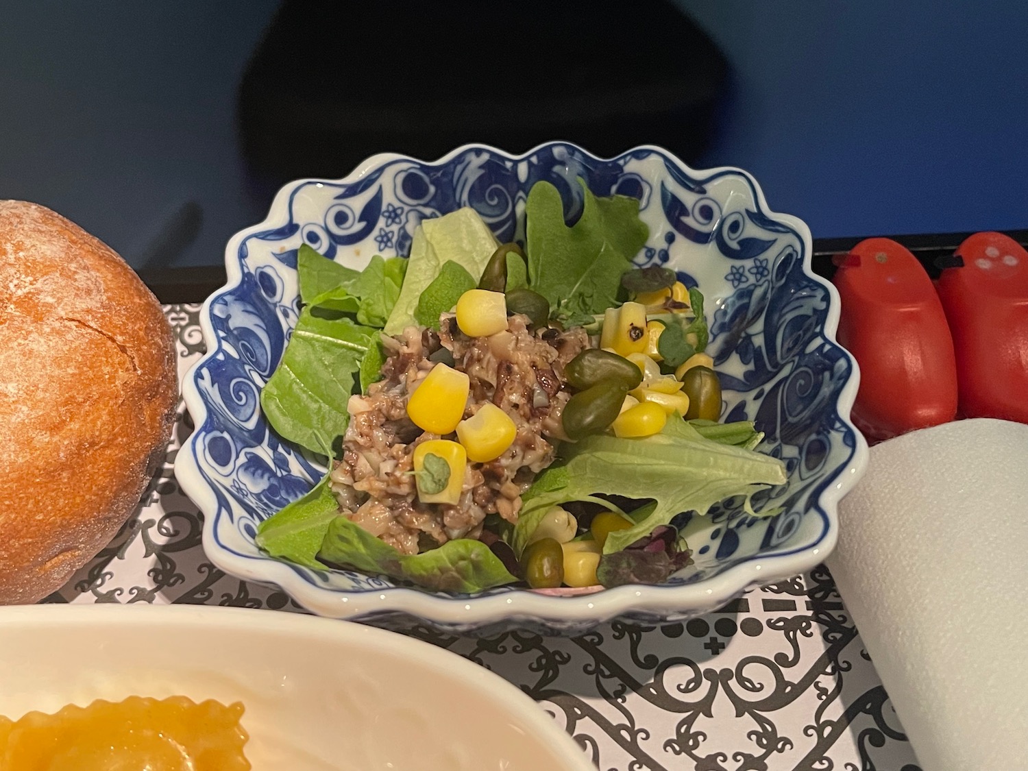 a bowl of salad with corn and lettuce