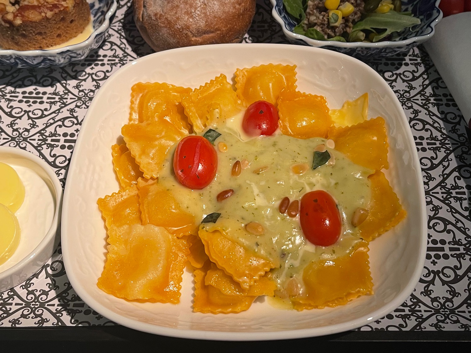 a plate of pasta with tomatoes and pine nuts