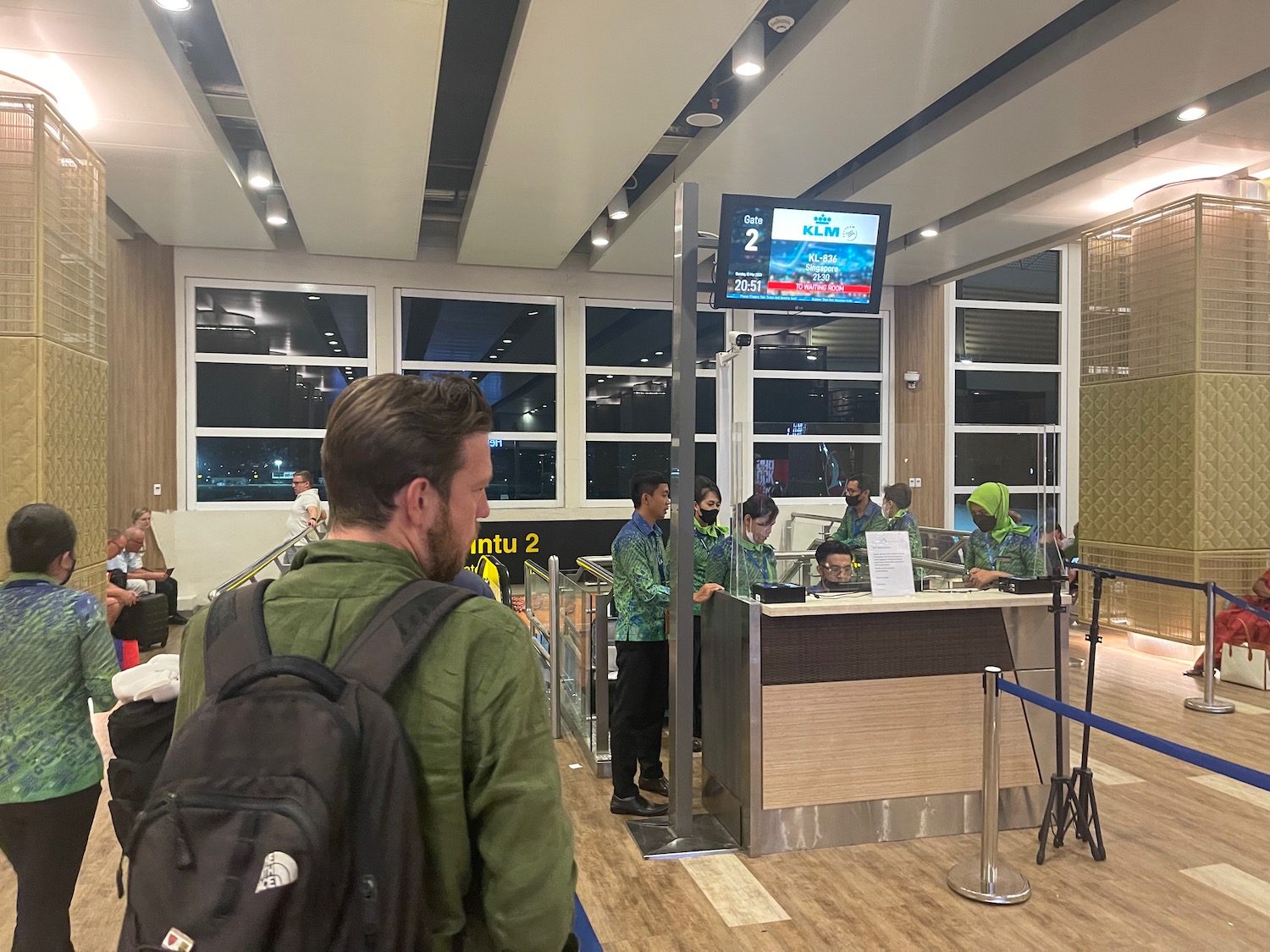 a group of people standing in a line at a check in counter