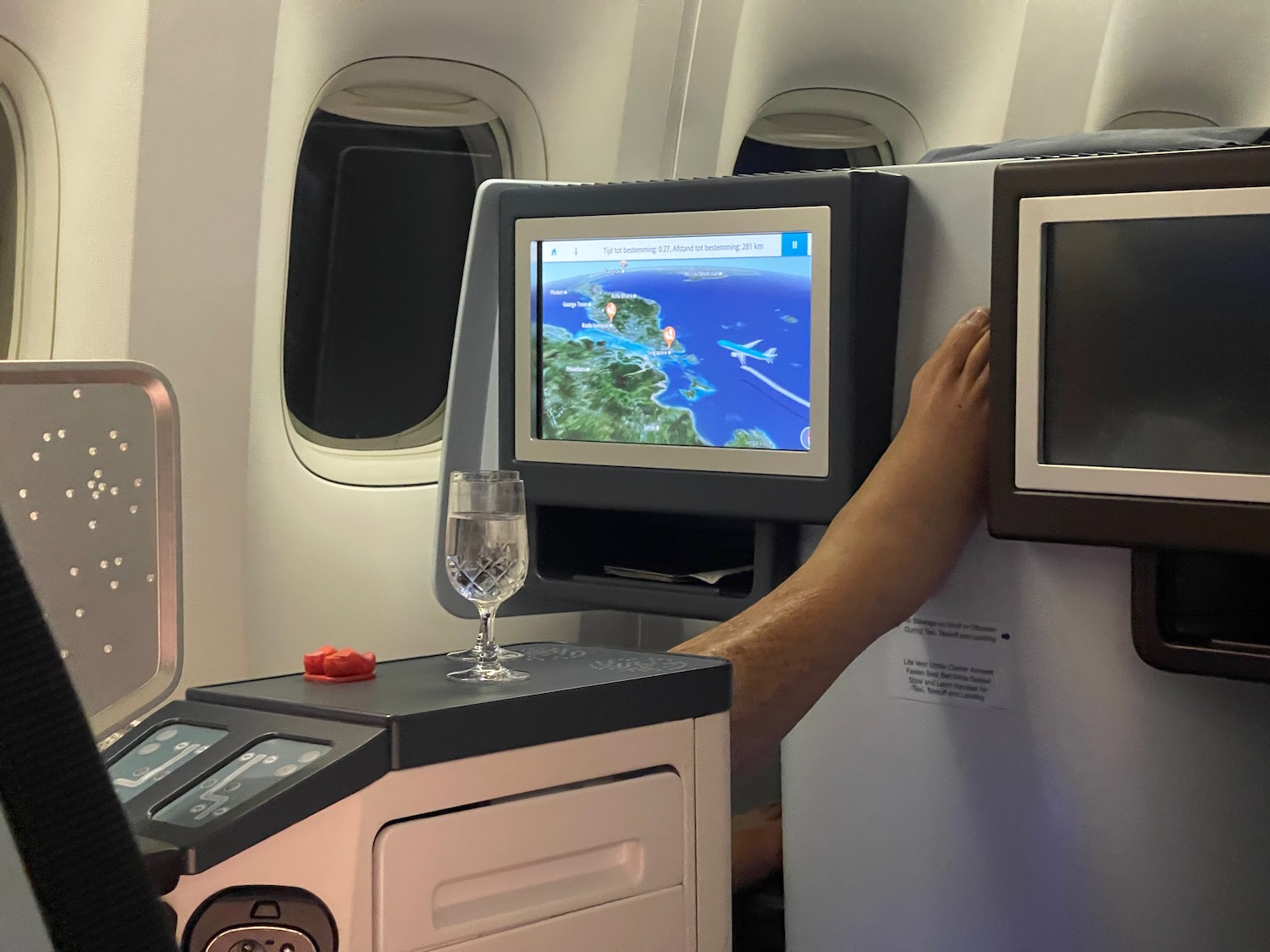 a person touching a screen on an airplane