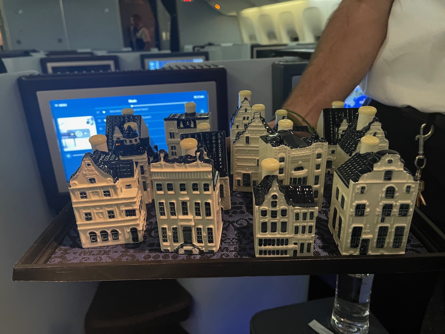 a person holding a tray of miniature buildings