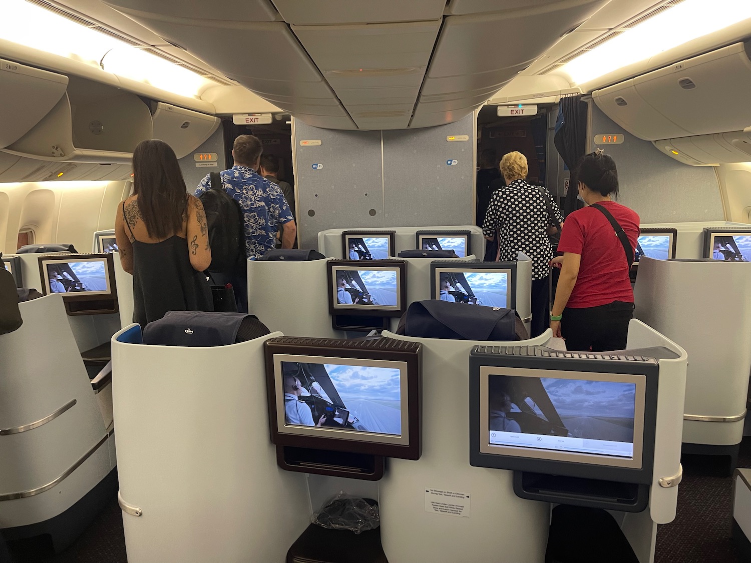 people in an airplane with several monitors