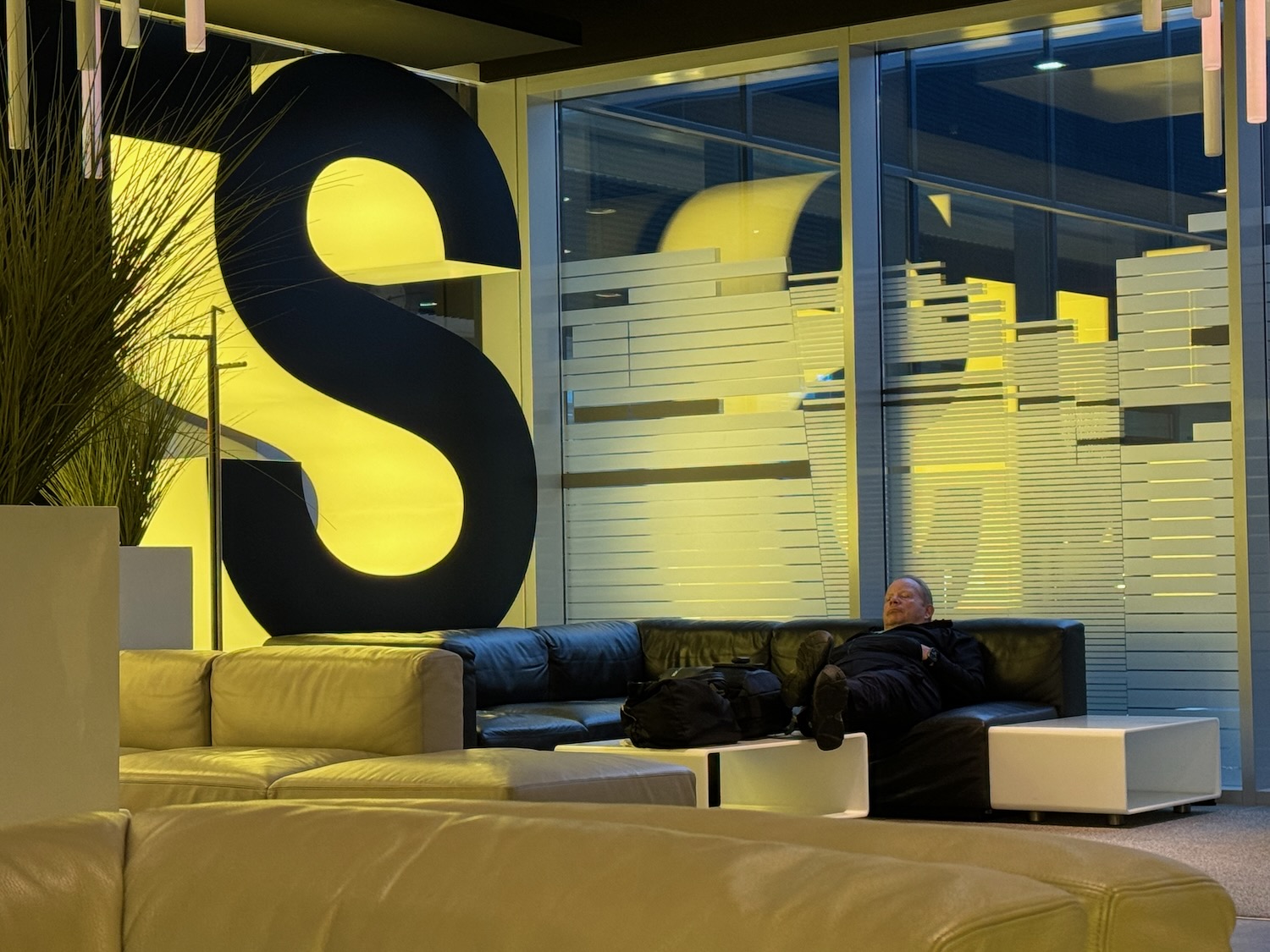 a man sitting on a couch in a room with large letters