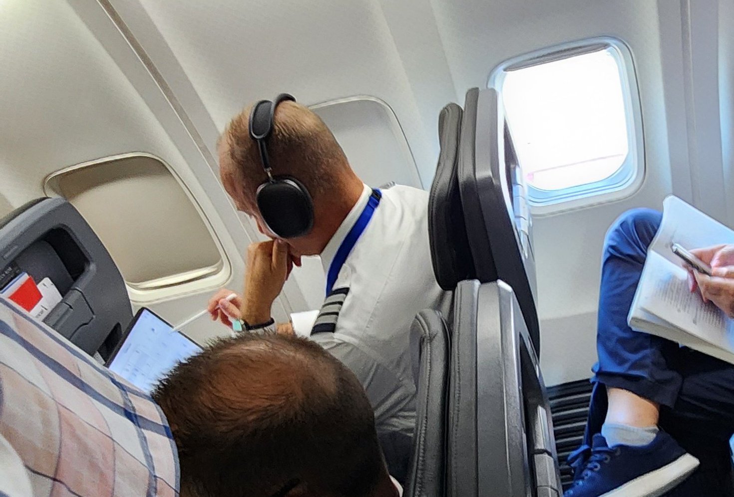 a man wearing headphones sitting in an airplane