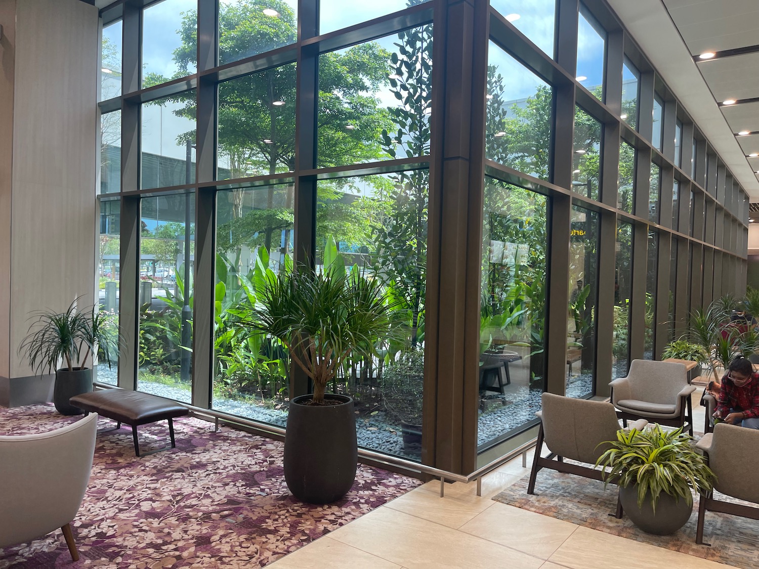 a room with glass walls and plants