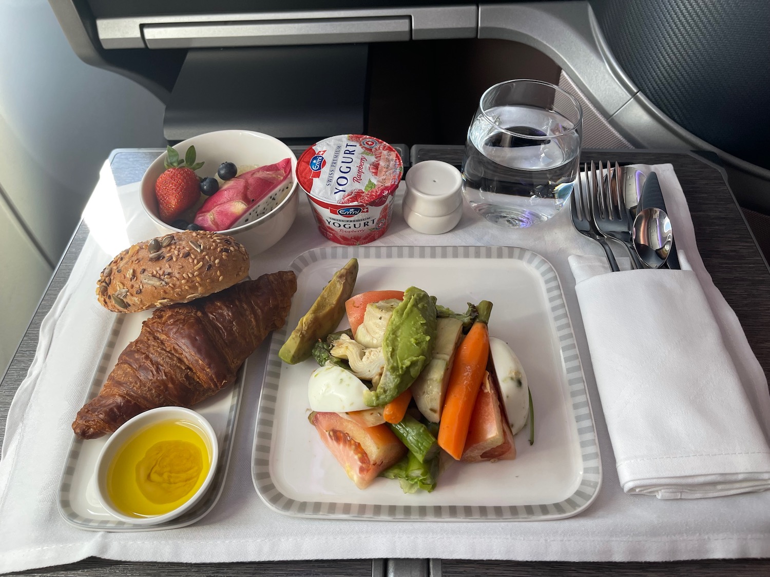 a plate of food and a glass of water on a tray