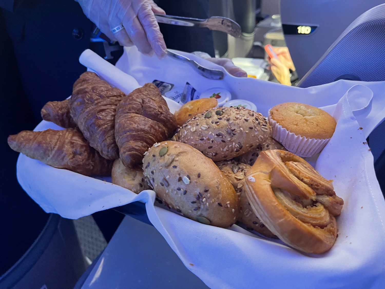 a tray of pastries and muffins on an airplane