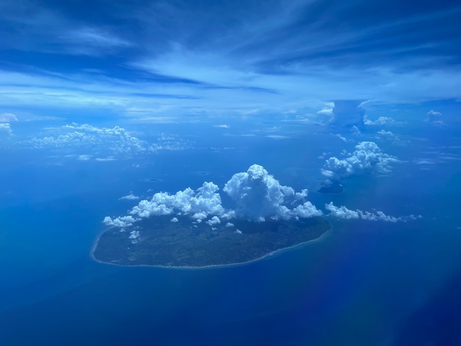 an island with clouds in the sky