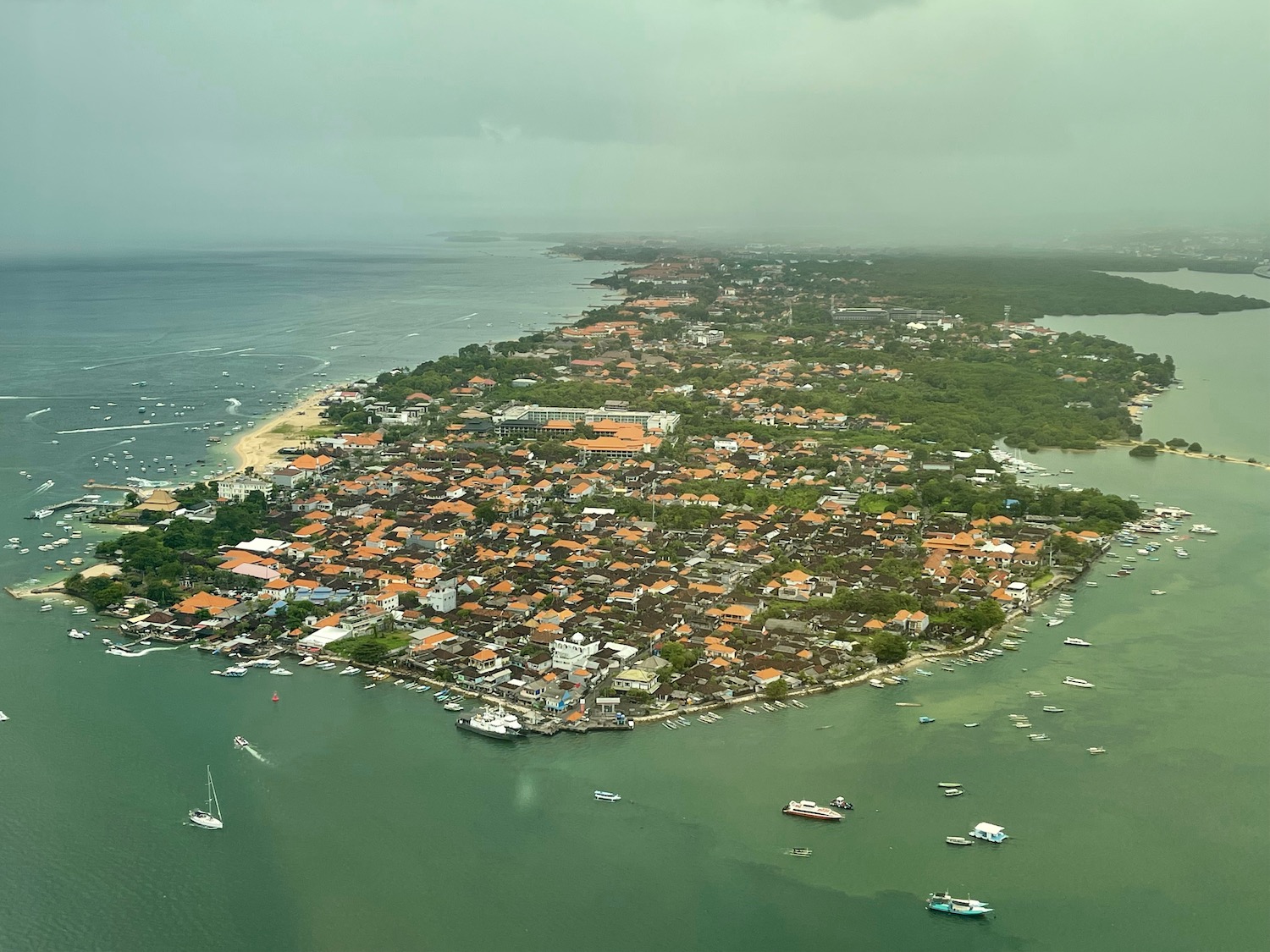 an aerial view of a small island with buildings and boats in the water