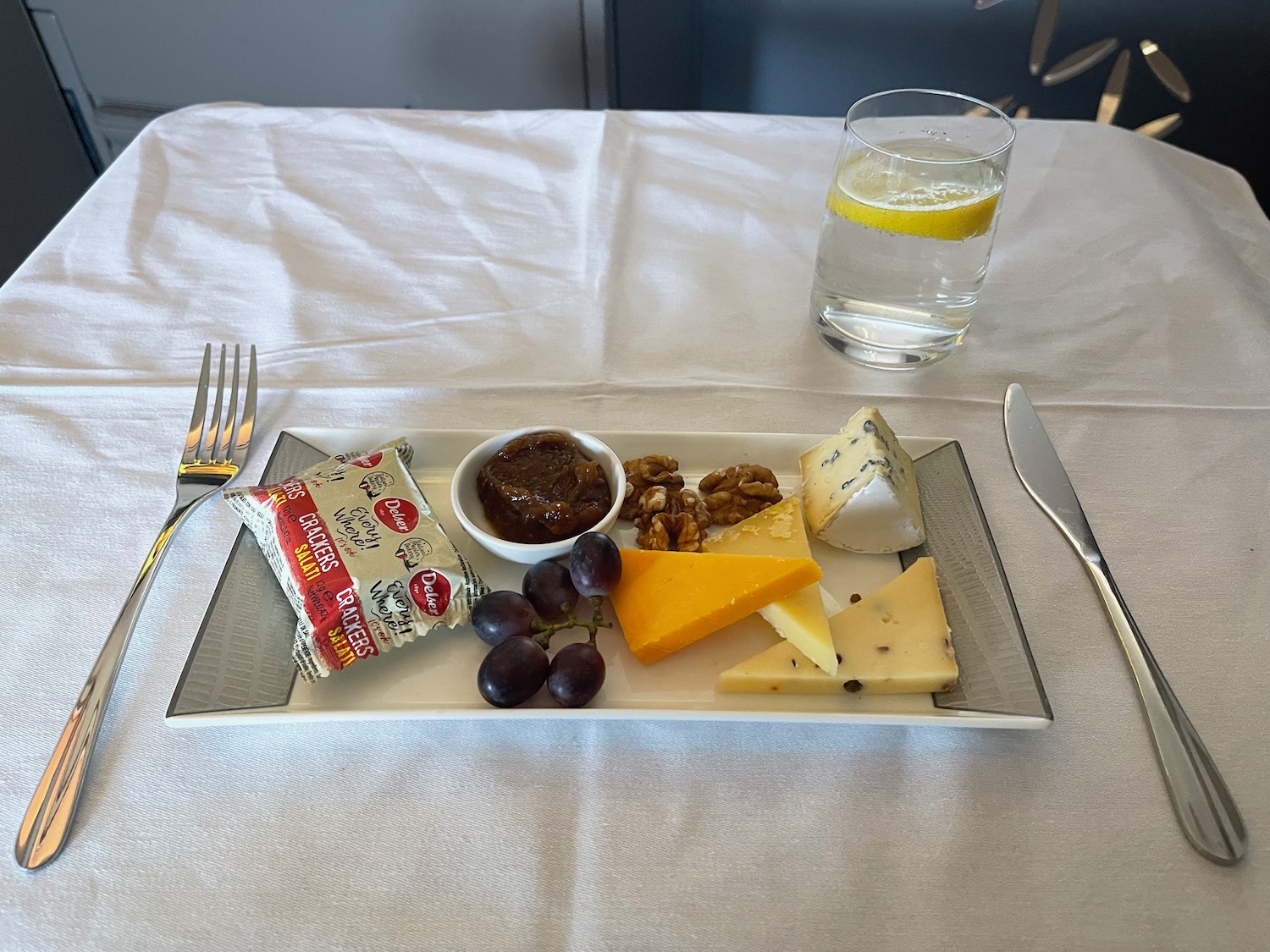 a plate of cheese and grapes on a table