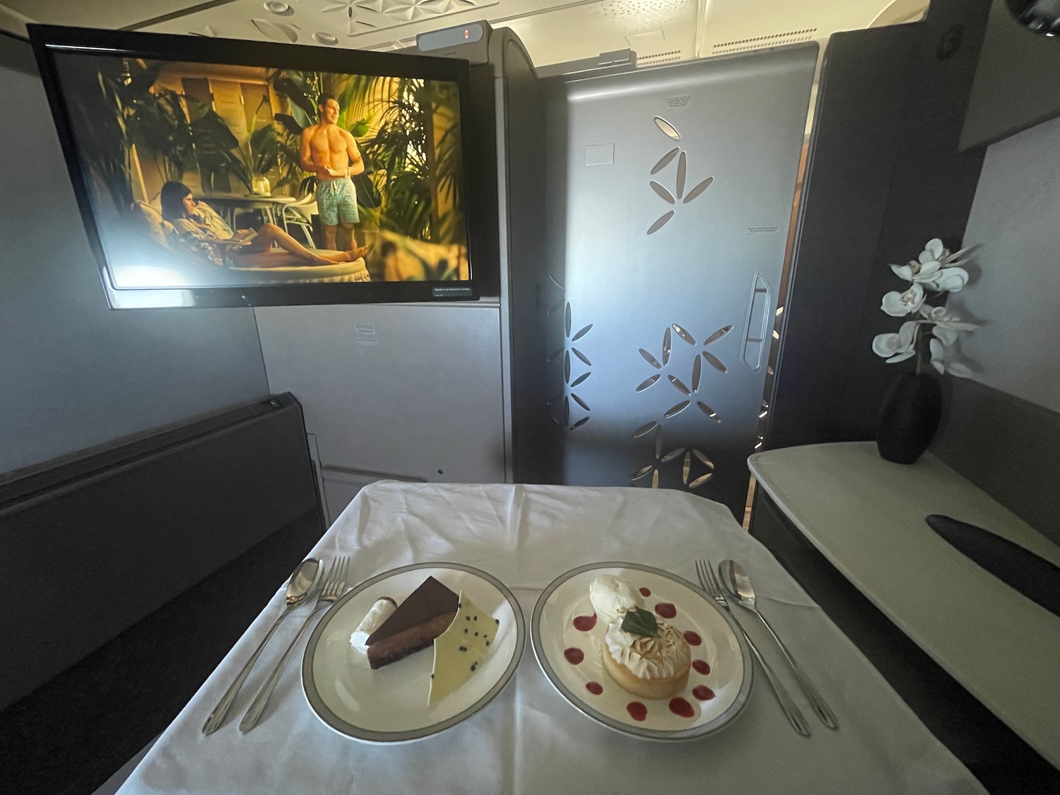 a table with plates of food on it and a television on the wall