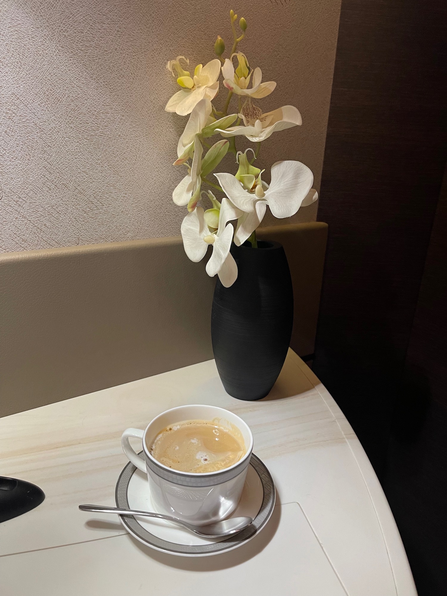 a cup of coffee and a vase with flowers