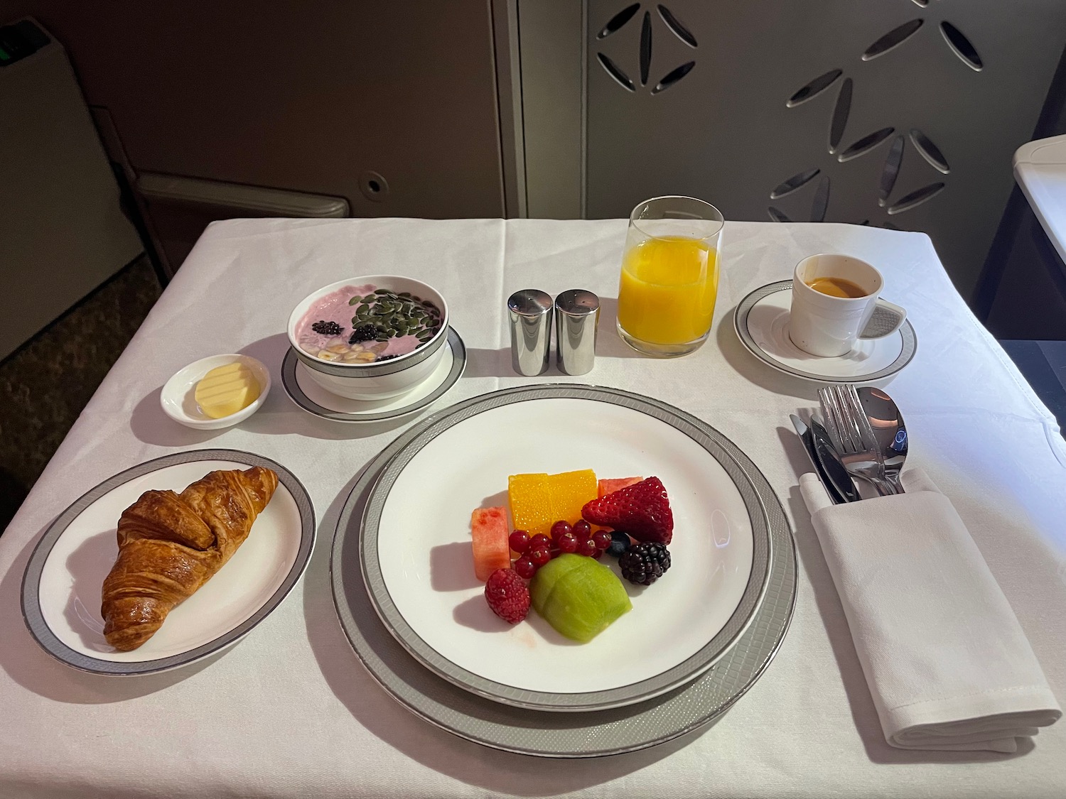 a table with plates of food and a croissant