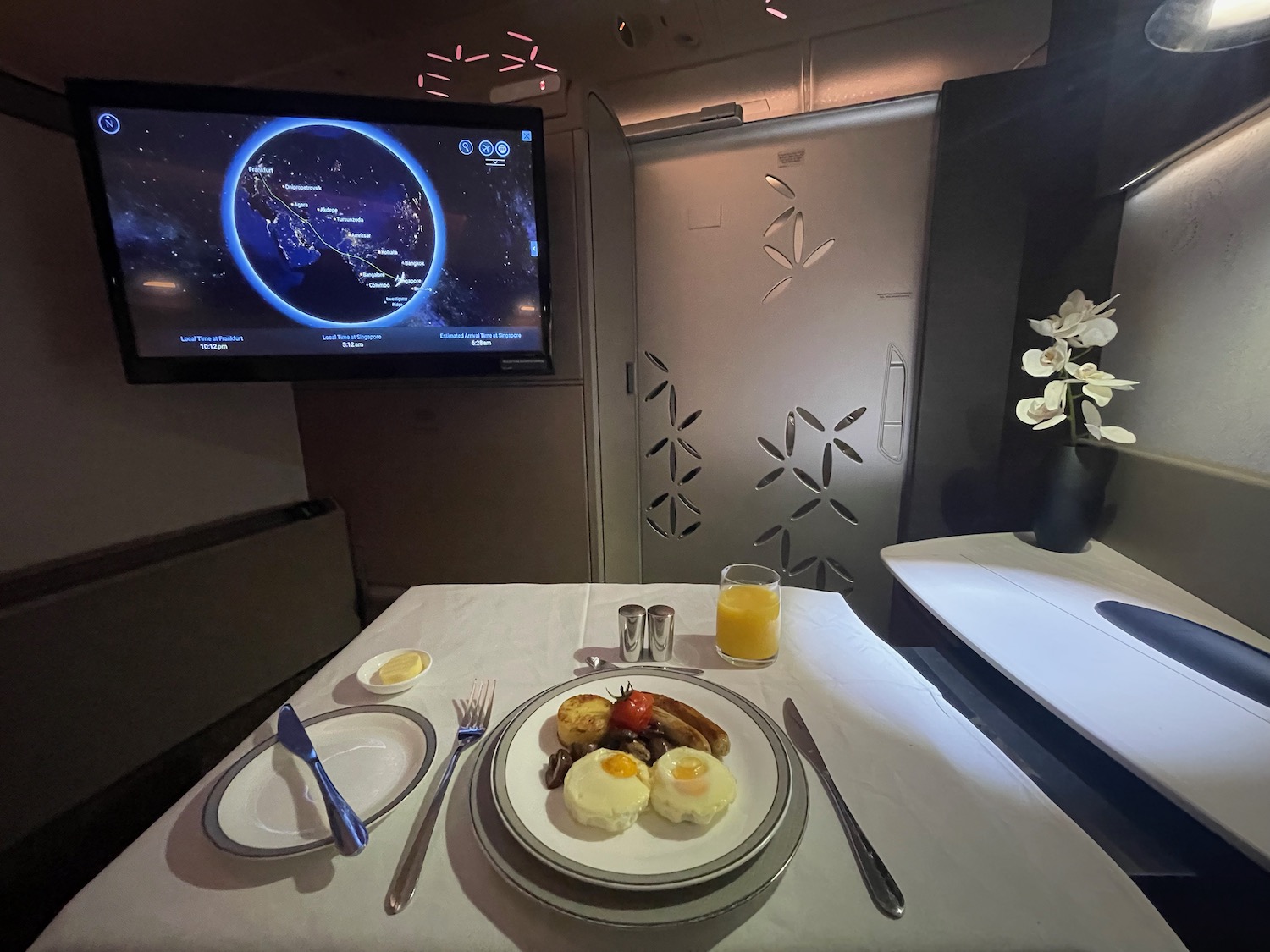 a plate of food on a table with a television on the wall