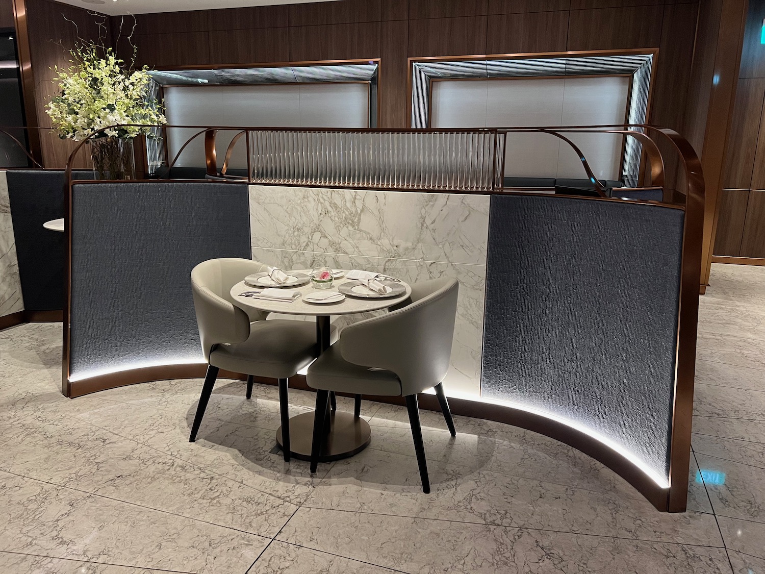 a table with plates and chairs in a room with a railing