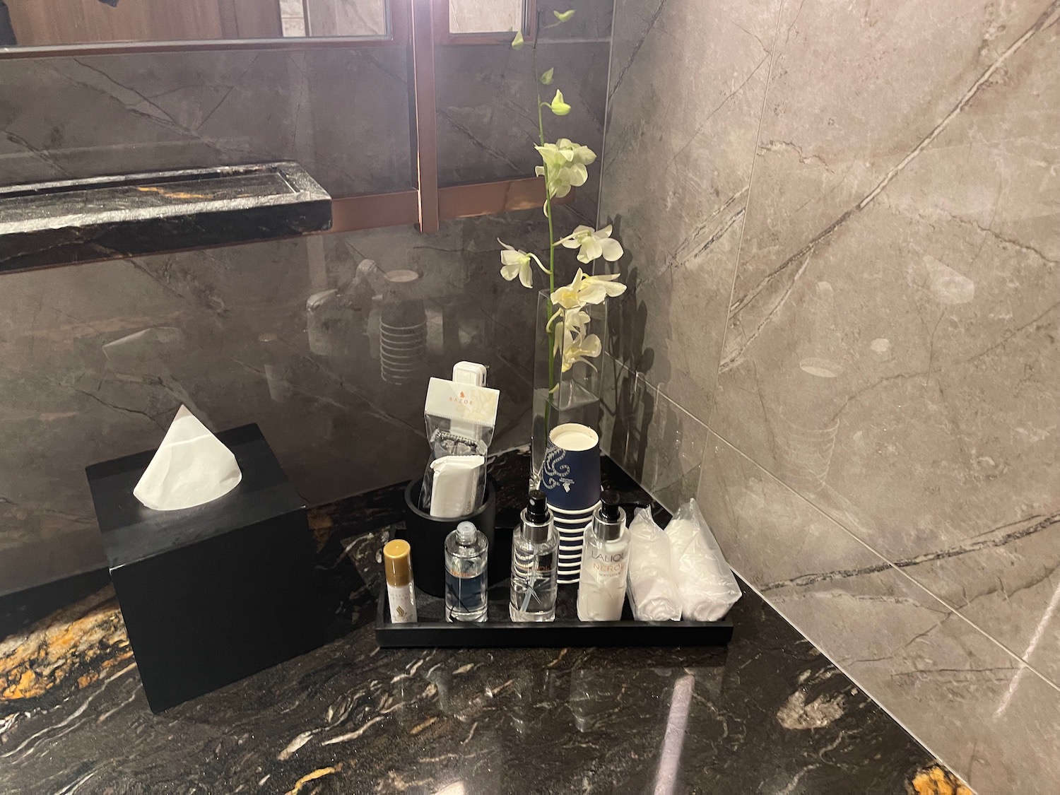 a bathroom counter with a flower and toiletries