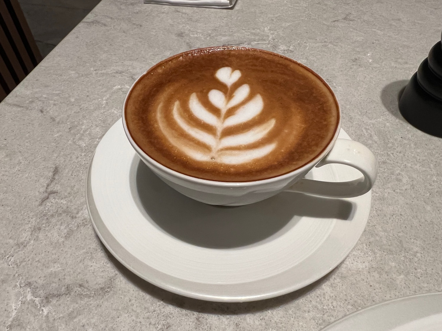 a cup of coffee with a leaf design on top