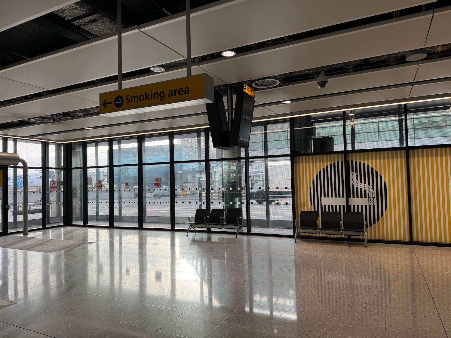 a large glass door with a sign and a smoking area