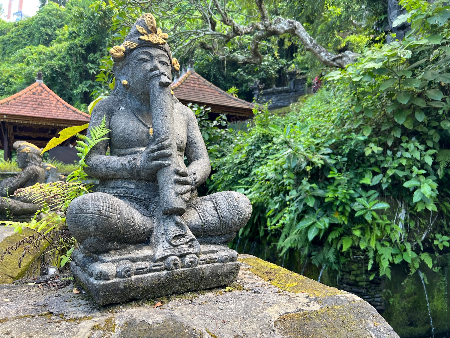 a stone statue of a man playing a flute