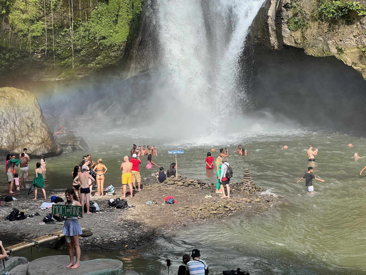 a group of people in a pool with a waterfall