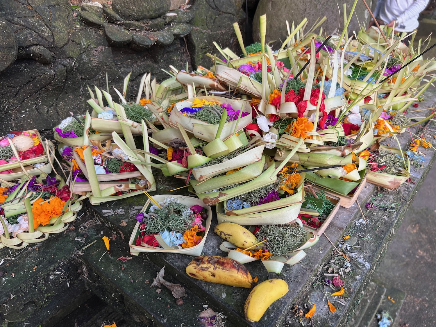 a pile of flowers and leaves on a stone surface
