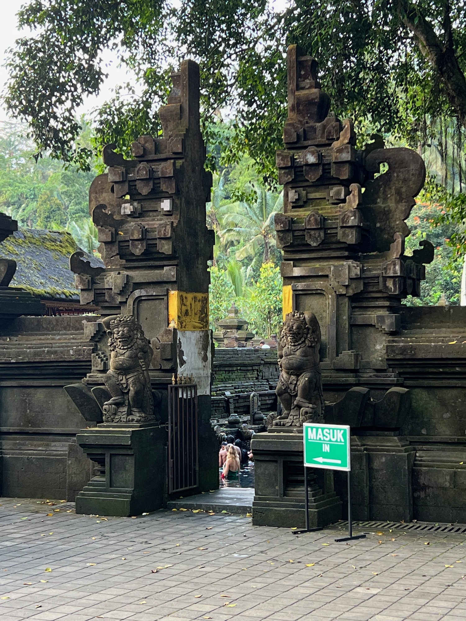 a stone gate with statues and a sign