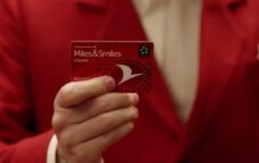 a person in a red suit holding a card