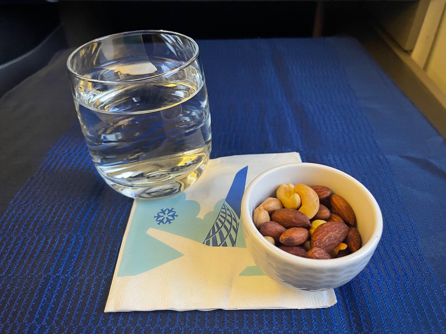 a bowl of nuts and a glass of water