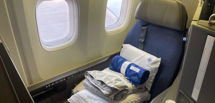 a seat with a pillow and blankets on it