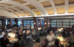 a group of people sitting in a room with chairs and lamps