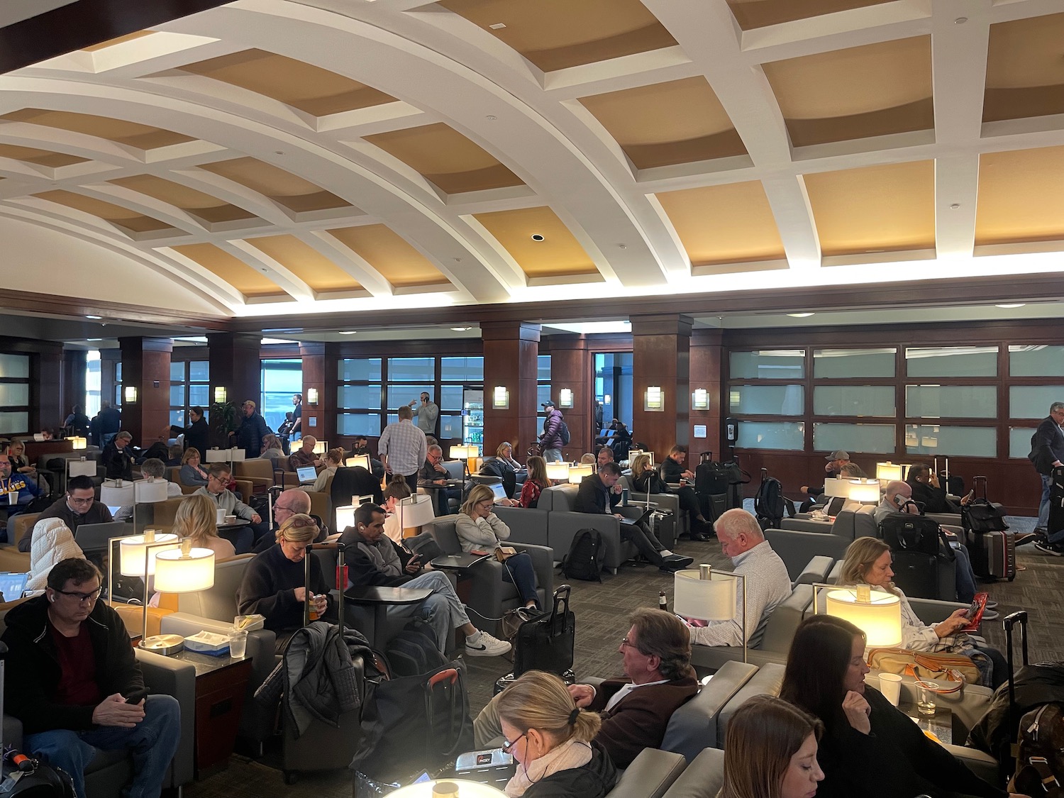 a group of people sitting in a room with chairs and lamps