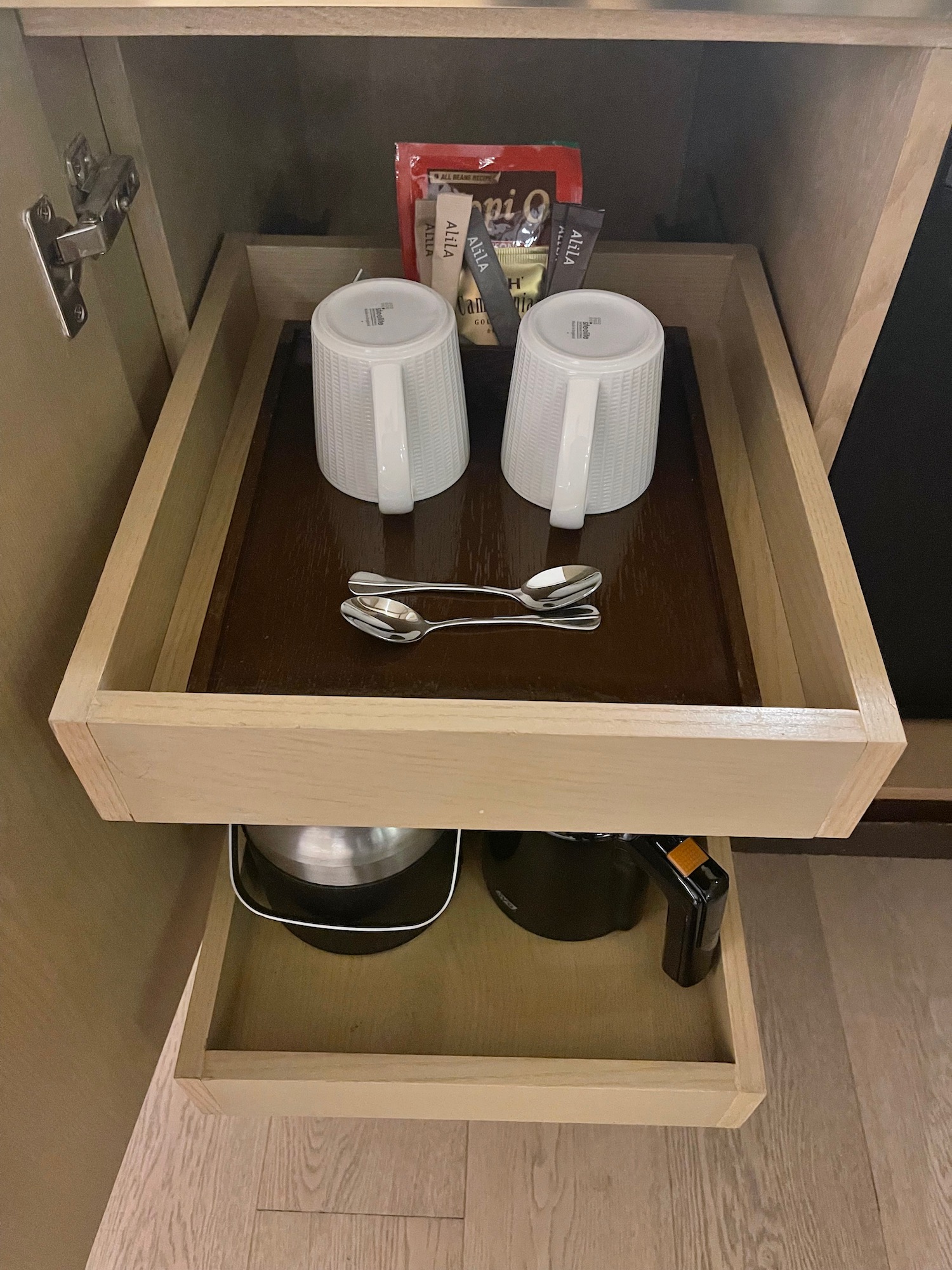 a drawer with cups and spoons