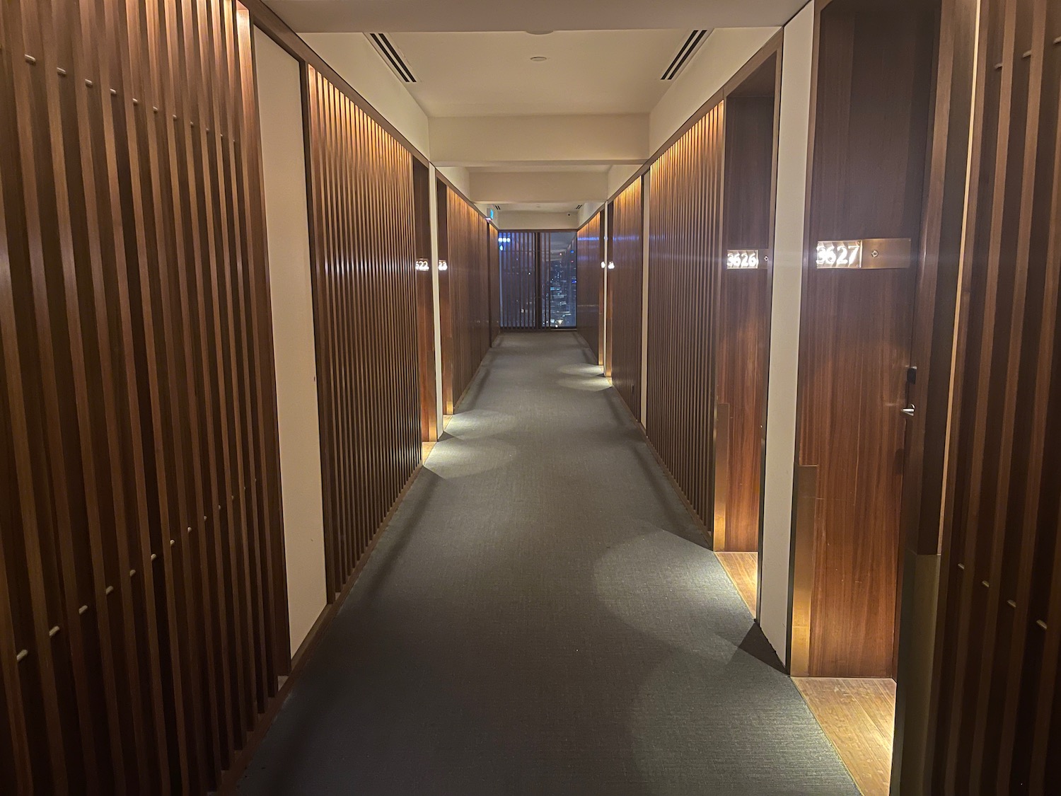 a hallway with wood panels and a window