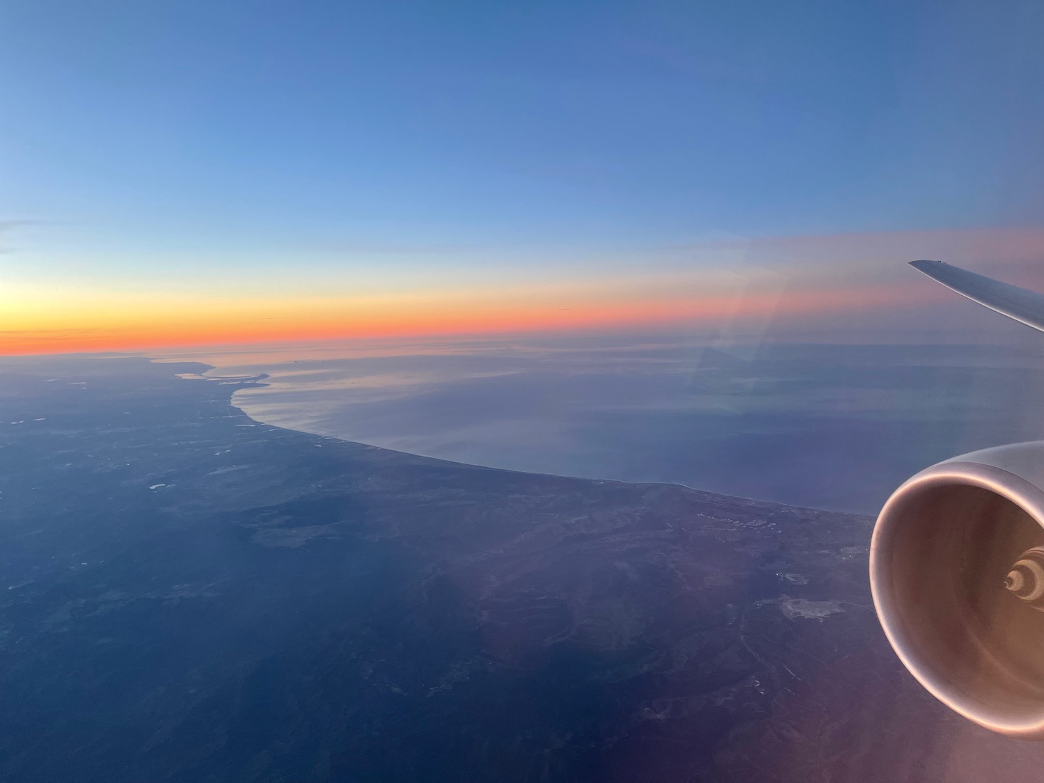 an airplane wing and a body of water