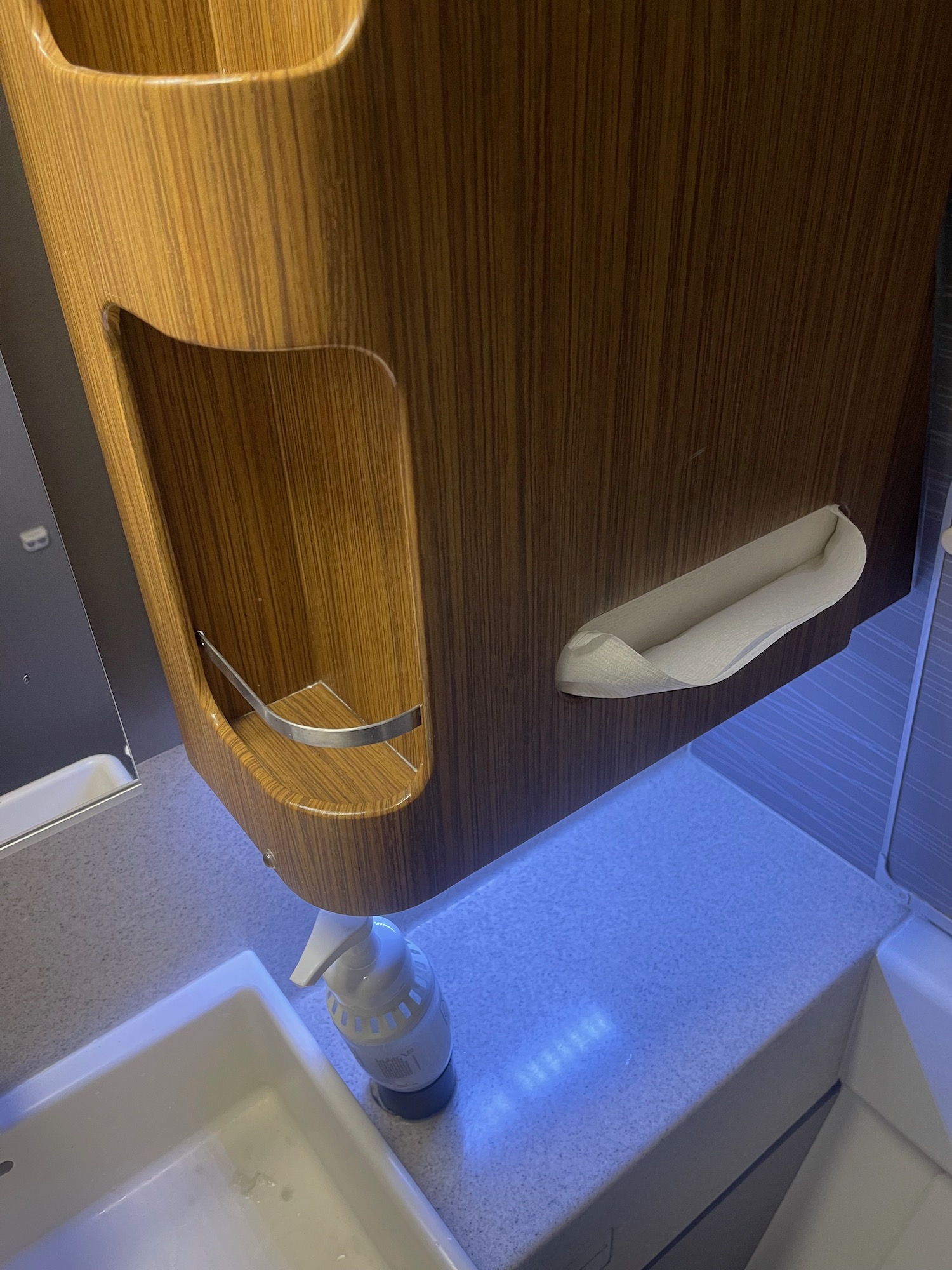 a wooden urinal with a paper towel holder