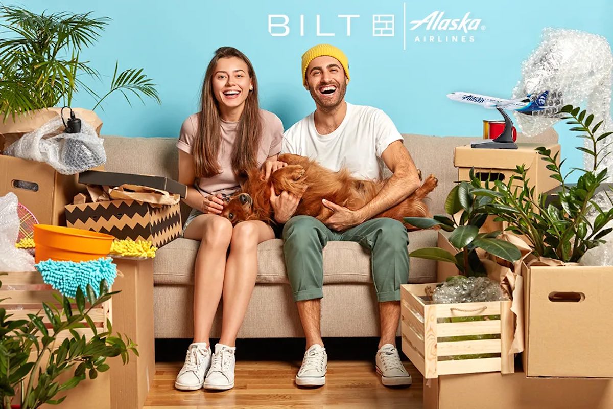 a man and woman sitting on a couch with a dog