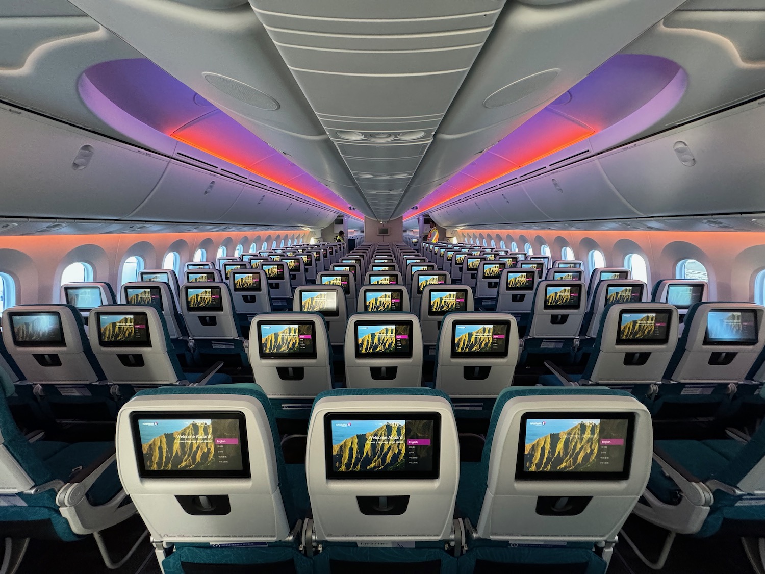 an airplane with rows of seats and monitors