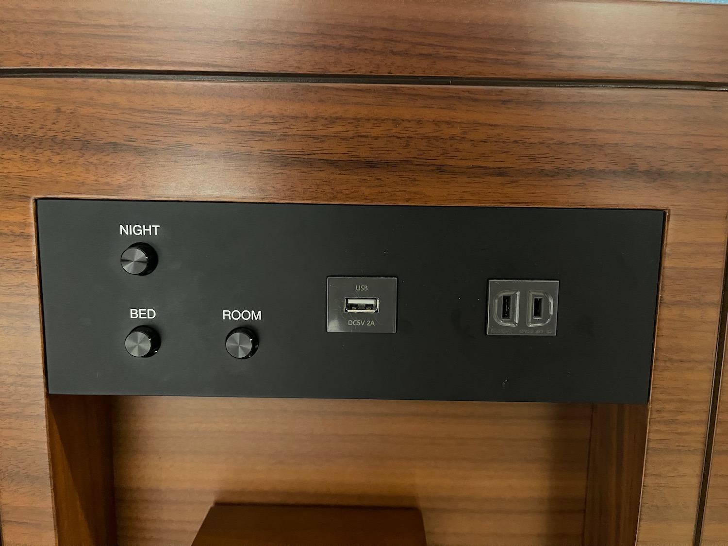 a black panel with buttons and switches on a wood surface