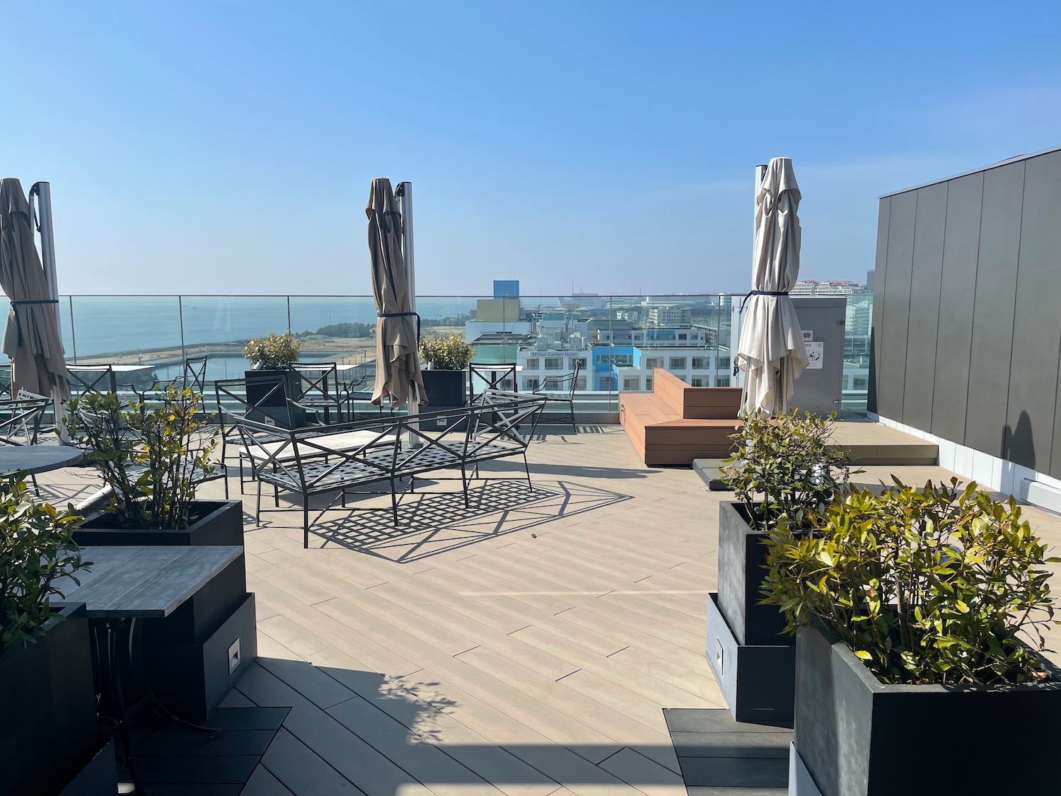 a deck with chairs and umbrellas and a view of the city