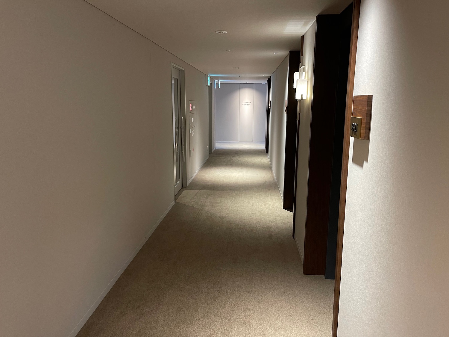 a hallway with doors and a light on the wall