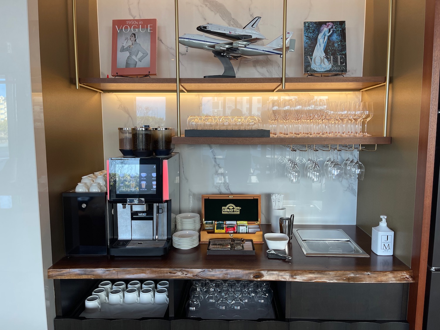a coffee machine and glasses on a shelf