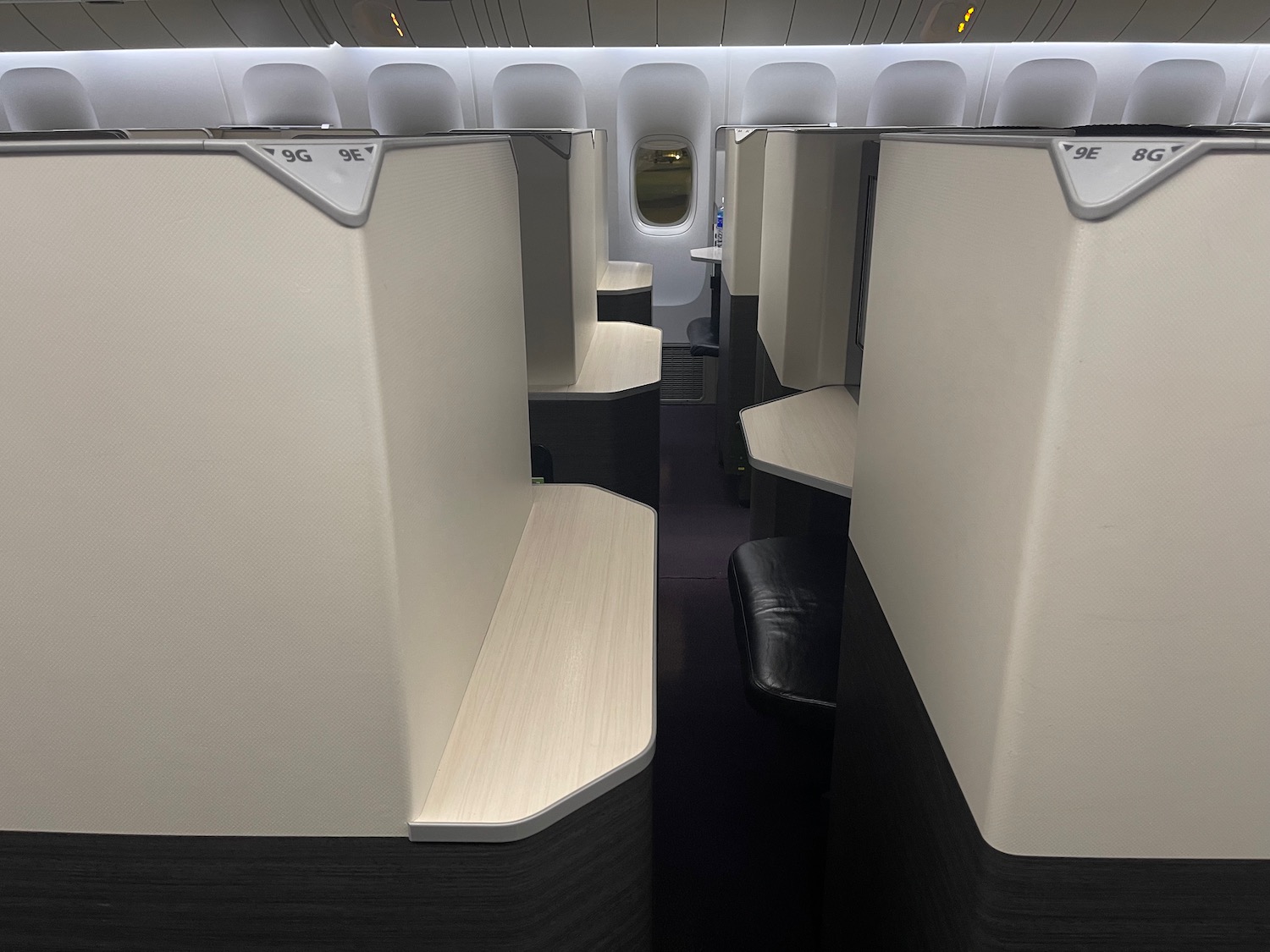 a row of white and black chairs in an airplane